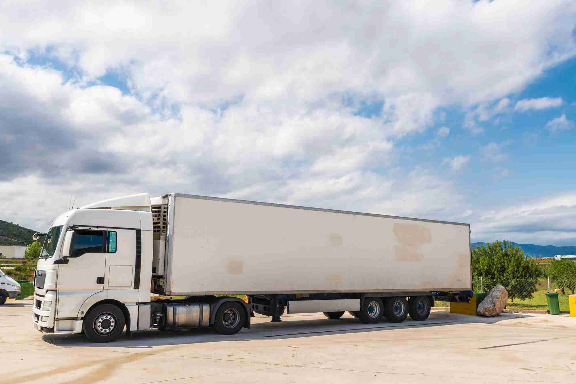 A white semi truck parked in a parking lot, representing efficient transportation and logistics.