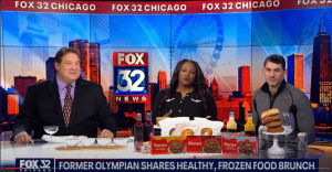 Three individuals on a news segment with frozen meal options on the table in a studio set with "Fox32 Chicago" in the background.